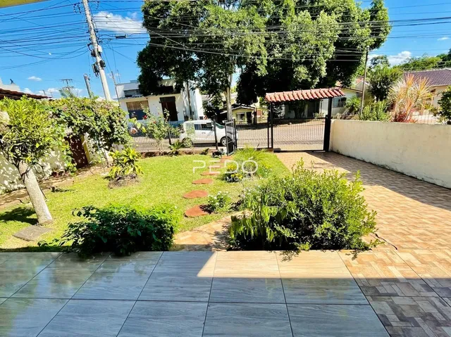 Vista externa de um quintal com gramado e muro branco em Lajeado.