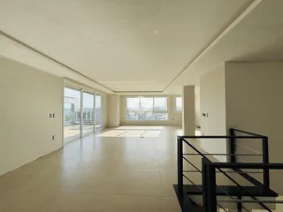 Ambiente interno de uma sala com piso de cerâmica e grandes janelas de vidro.