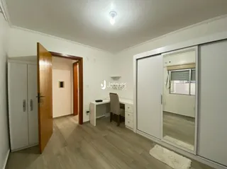 Hall de entrada com piso de madeira e portas de madeira na residência.