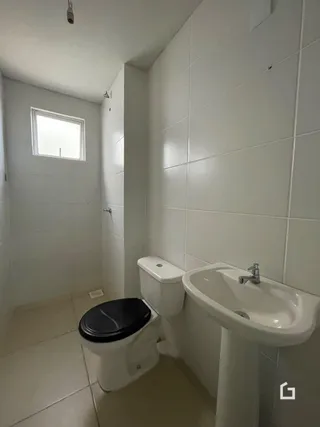 Foto de um banheiro com revestimento cerâmico branco.