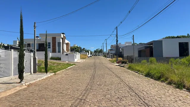 Uma rua de paralelepípedos em Lajeado, Brasil, com residências ao fundo.