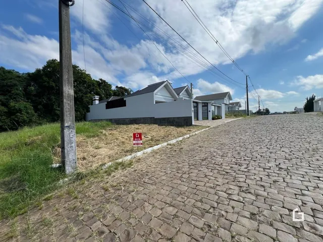 Fachada de uma casa em Lajeado, Brasil, com terreno gramado e estrada de paralelepípedos.