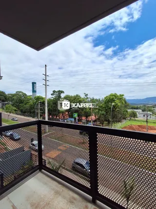 Vista externa de um balcão com vista para uma rua e vegetação em Lajeado.