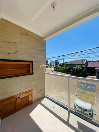 Vista interna de uma área com paredes de madeira e abertura para o exterior.