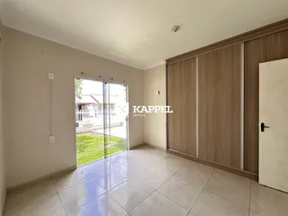 Ambiente interno com piso de cerâmica e porta de vidro que dá acesso ao quintal.