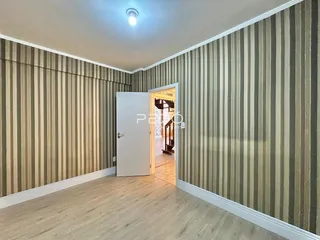 Hallway com revestimento de parede listrado e piso de madeira.