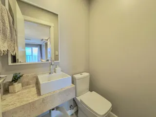 Foto de um banheiro com bancada de mármore e vaso sanitário.