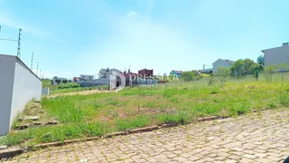 Vista externa de uma propriedade com gramado e área pavimentada.