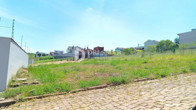Vista externa de uma propriedade com gramado e área pavimentada.