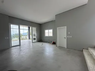 Sala ampla com portas de vidro que oferecem vista para a paisagem externa.