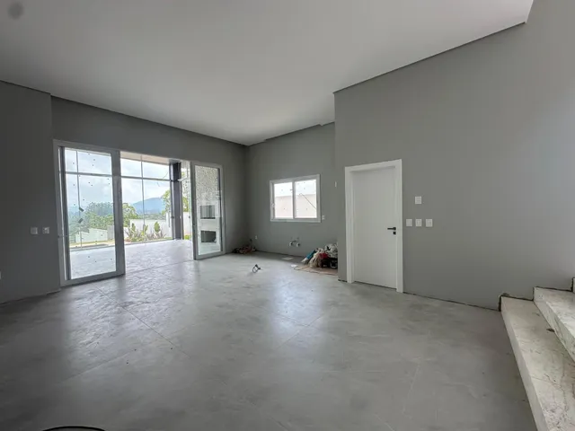 Sala ampla com portas de vidro que oferecem vista para a paisagem externa.