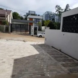 Fachada externa de um imóvel em Lajeado, Brasil, com parede branca e piso de concreto.