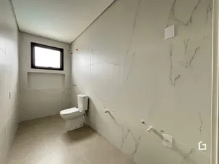 Corredor interno com paredes brancas e piso de cerâmica.