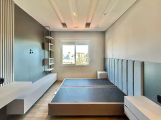 Quarto moderno com duas camas e janela de vista para a cidade.