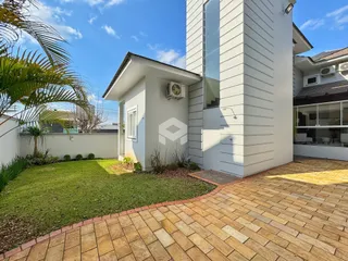 Fachada de uma residência com jardim e pátio em Lajeado.