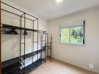 Ambiente interno com estantes pretas e piso de madeira clara.
