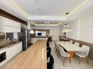 Ambiente de cozinha e jantar moderno com ilha central.