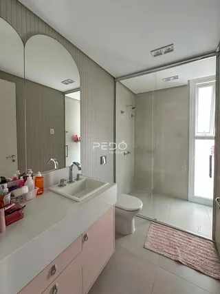 Banheiro moderno com bancada e box de vidro.