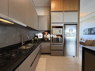Cozinha moderna com bancadas escuras e eletrodomésticos em aço inoxidável.