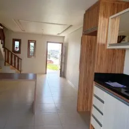 Foto de um corredor interno com piso de cerâmica e escadaria.