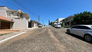 Vista da rua em Lajeado, Brasil, mostrando casas residenciais e uma estrada de paralelepípedos.