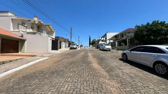 Vista da rua em Lajeado, Brasil, mostrando casas residenciais e uma estrada de paralelepípedos.