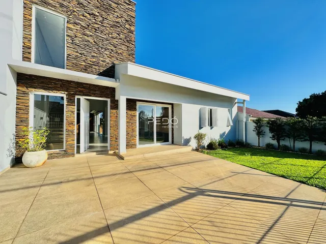 Fachada de uma residência moderna com revestimento de pedra e jardim em Lajeado, Brasil.