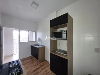 Foto de uma cozinha interna com armários e piso de madeira clara.