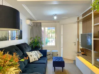 Sala de estar com sofá azul e janela com vista para o exterior.