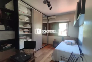 Quarto com cama e armário em ambiente interno com piso de madeira.
