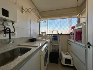 Imagem de uma cozinha com pia e máquina de lavar roupa.