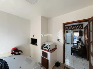 Interior de uma sala com parede branca e porta de madeira.