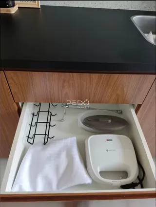 Interior de um armário com utensílios de cozinha e eletrodomésticos.