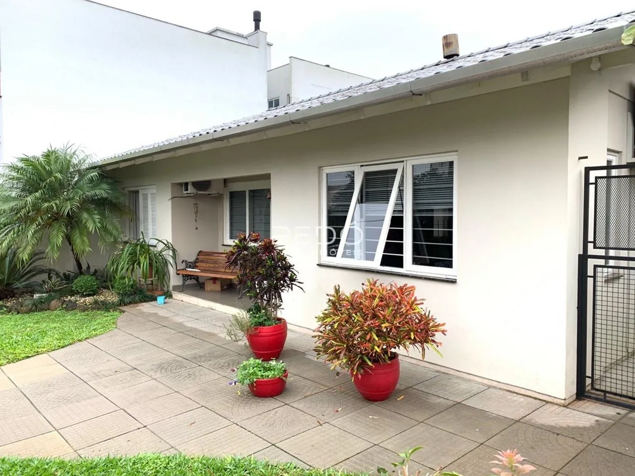 Fachada externa de uma casa em Lajeado, Brasil, com jardim e pátio.