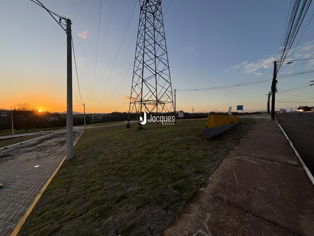 Vista externa de um terreno com poste de energia e gramado.