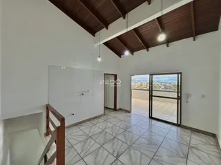 Ambiente interno de uma sala com teto inclinado e piso de cerâmica.