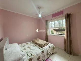 Quarto com cama e janela em uma residência.