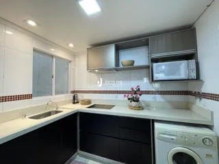 Cozinha com armários brancos e bancada clara.