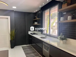 Cozinha moderna com bancada clara e armários escuros.