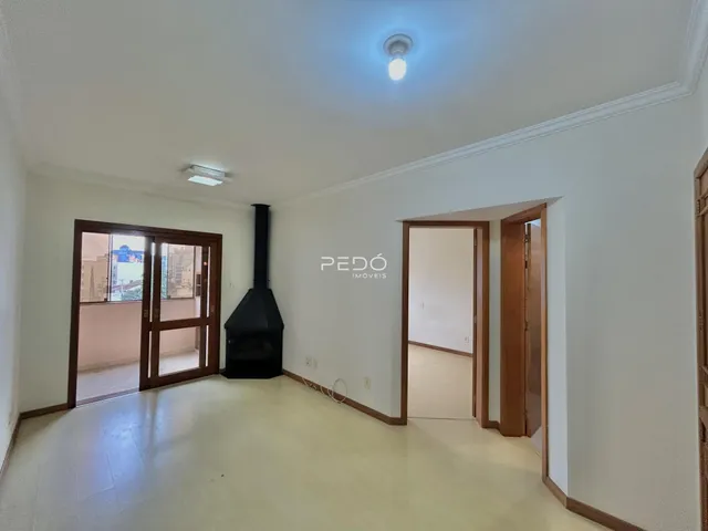 Ambiente interno de uma sala com piso claro e portas de madeira.