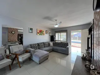 Sala de estar com sofá e poltronas em um ambiente claro.