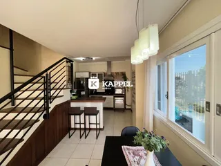 Vista interna de uma área com escada e cozinha.