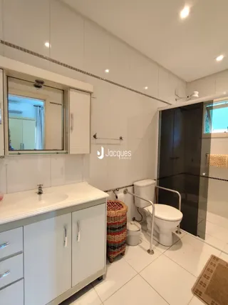 Foto de um banheiro com revestimento branco e louças brancas.