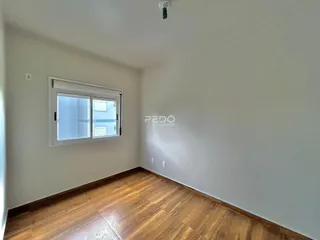 Sala de estar com piso de madeira e janela em um imóvel no Brasil.