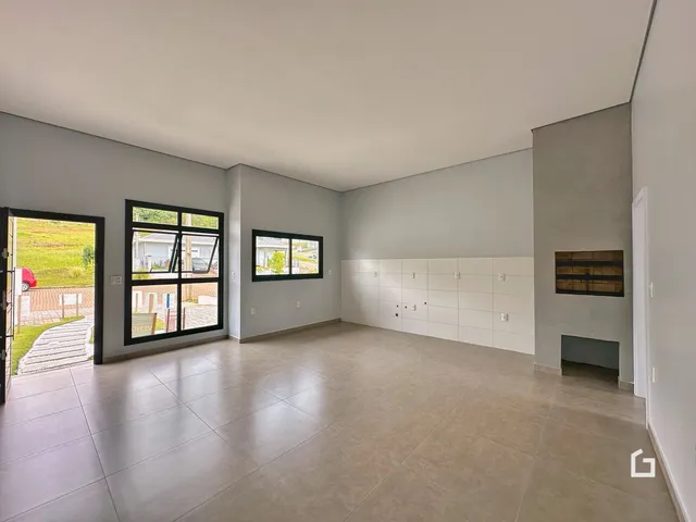 Ambiente interno de uma sala ampla com piso de cerâmica clara.