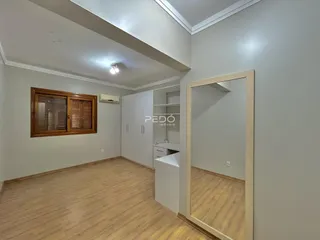 Ambiente interno de uma sala com piso de madeira clara.