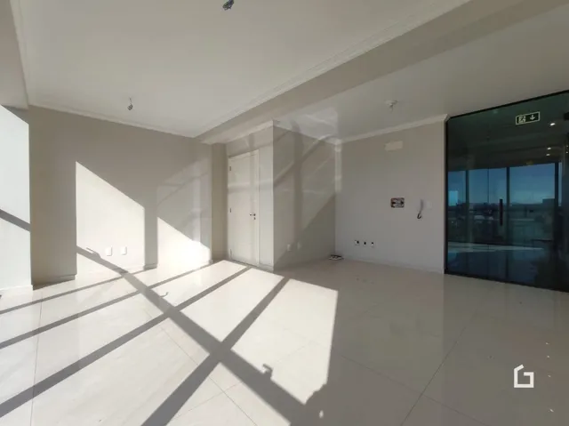Interior de uma sala com piso claro e paredes brancas.