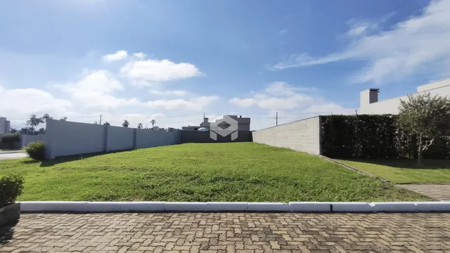 Vista externa de um terreno com gramado e muros brancos em Lajeado, Brasil.