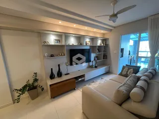 Sala de estar moderna com sofá e painel de TV em um apartamento no Brasil.