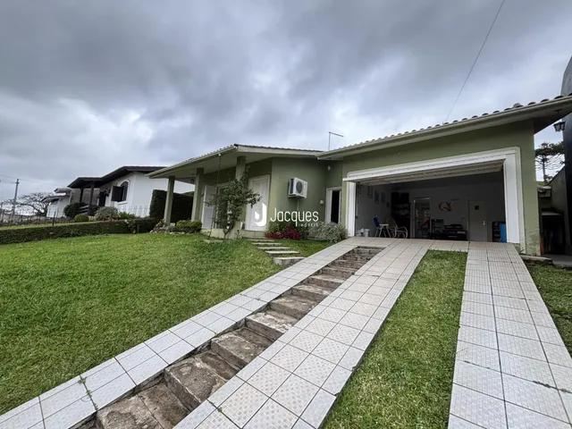 Vista da fachada de uma residência em Lajeado, Brasil, com jardim e calçada.